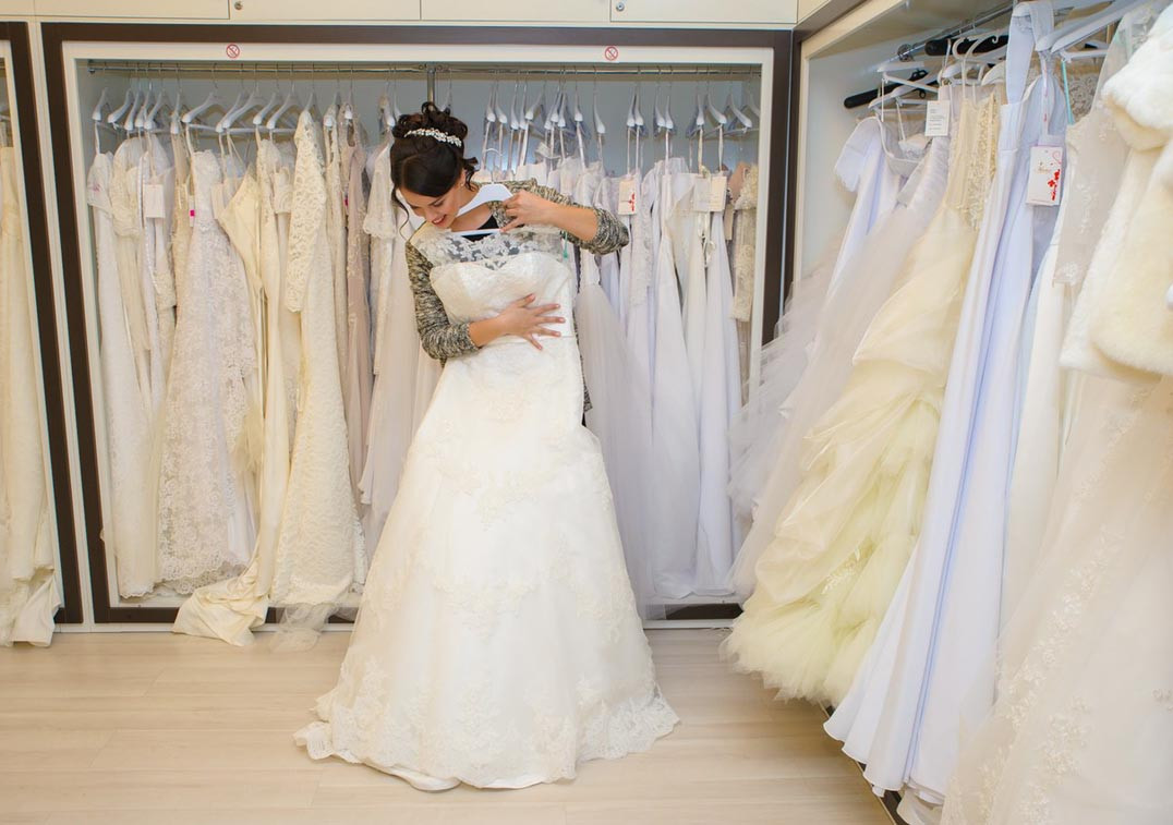 Магазин купит свадебное платье. Примерка свадебного платья. Невеста в свадебном салоне. Невеста примеряет свадебное платье. Примерка свадебного платья в салоне.